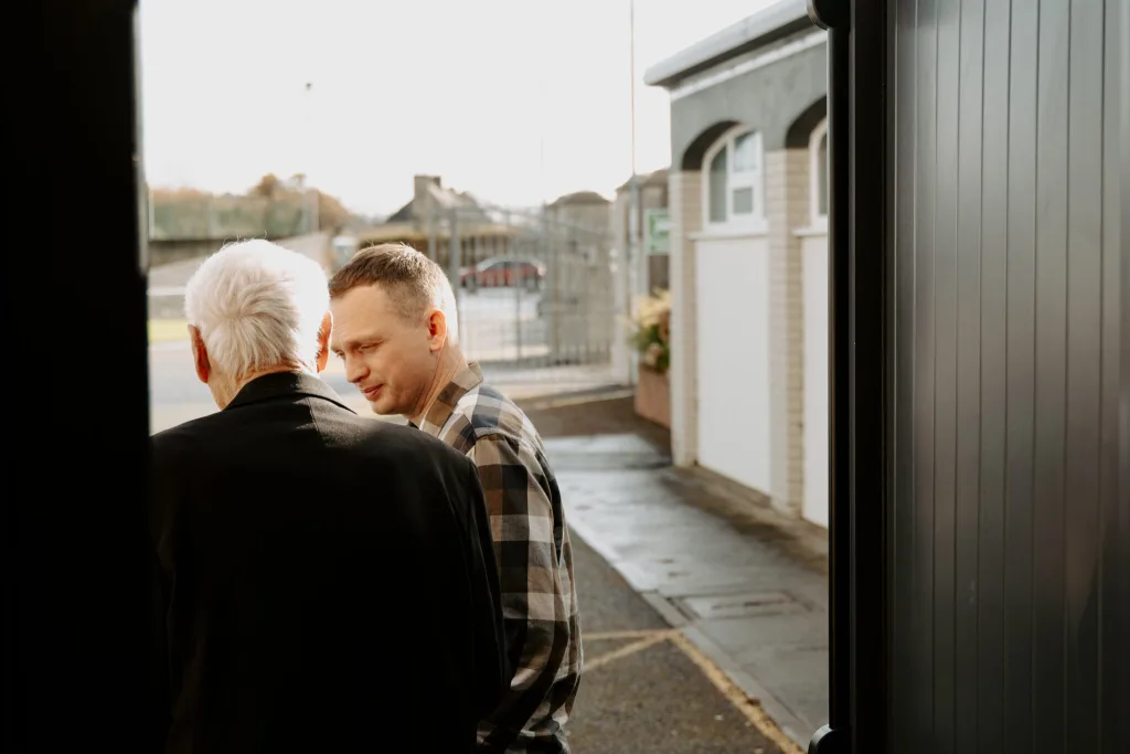 Church planter in a chequered shirt talking to an older man dressed in a suit jacket